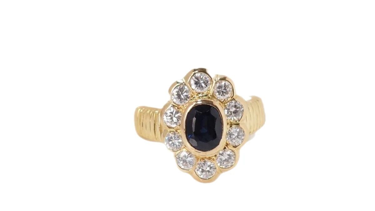 Bague entourage en or jaune, saphir ovale et diamants