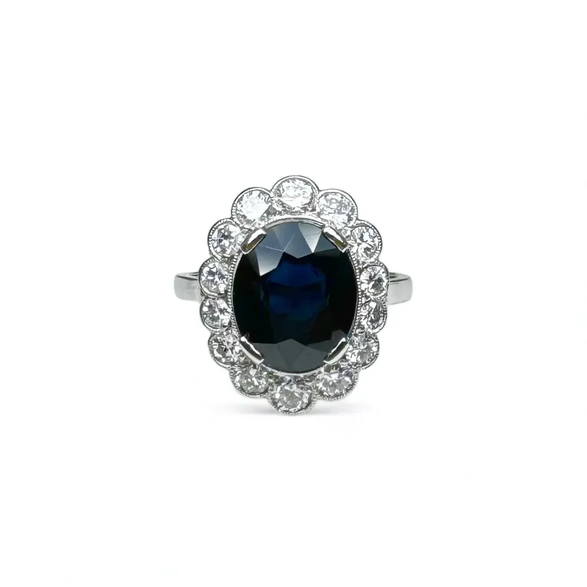Bague marguerite en platine centrée d’un saphir entouré de diamants.